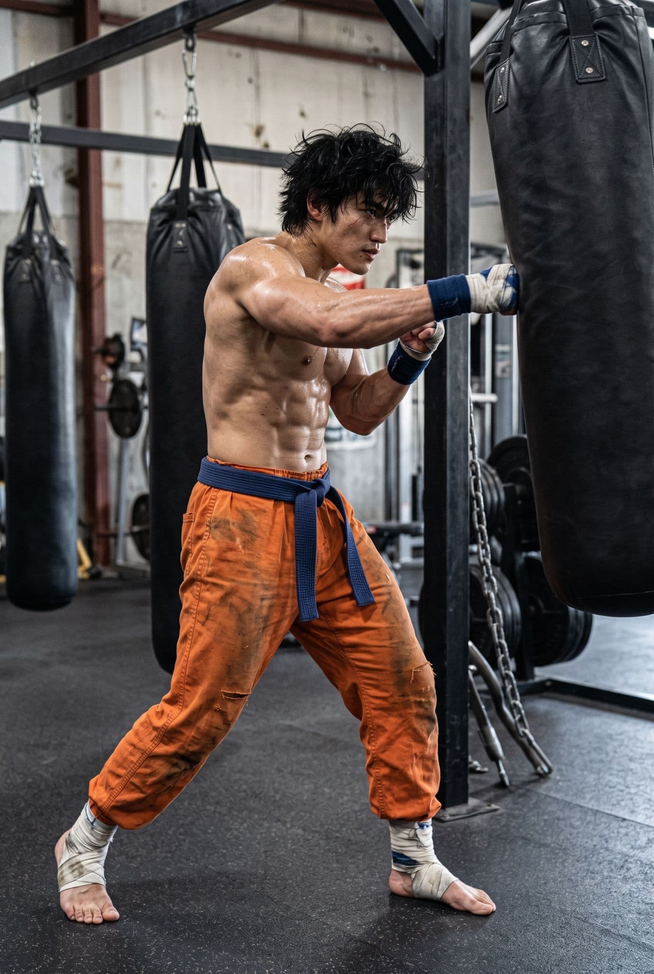 Kuroha's wrapped fist hitting a heavy bag